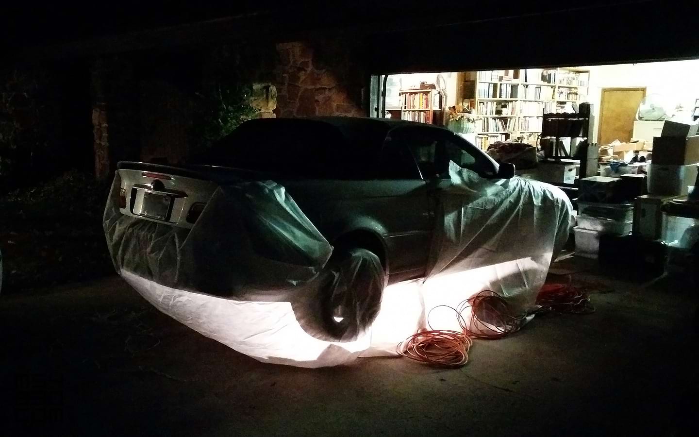 The E46 on jack stands in the middle of the night with work being performed in a windstorm.