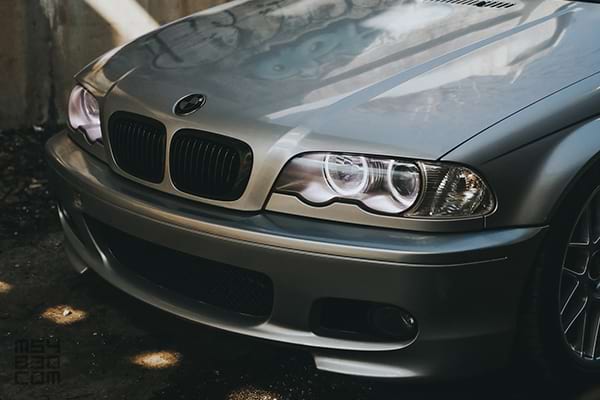 Close-up of the hood, grille, and bumper with Angel Eye headlights illuminated.