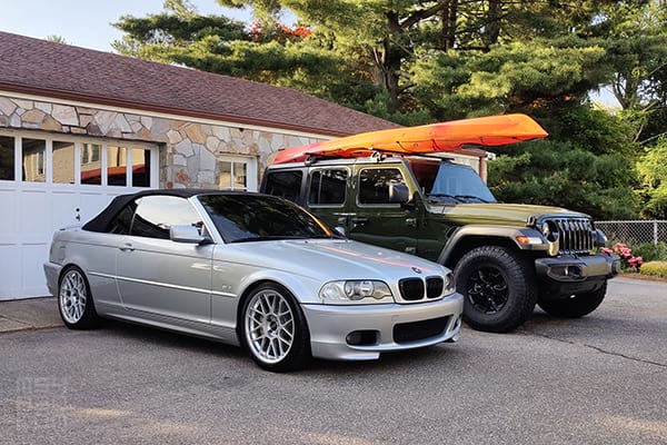A freshly detailed E46 and a Jeep Wrangler with a kayak strapped to the roof ready for adventure.